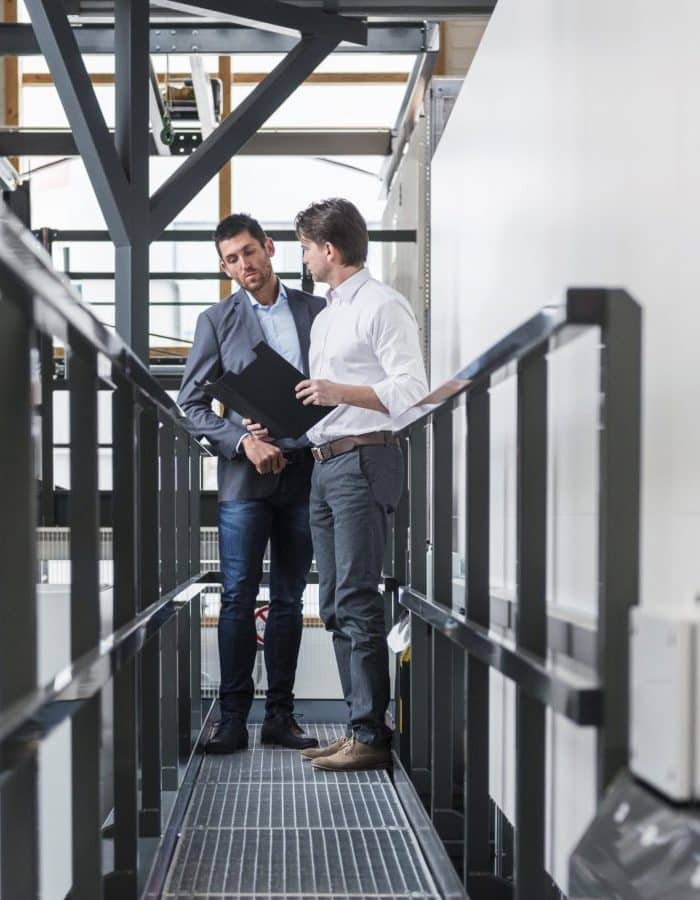 Two business men talking in a metal supply factory